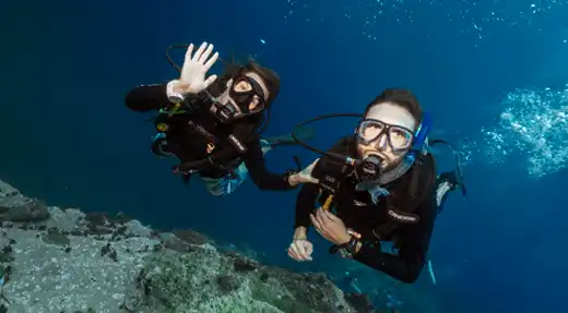 Two scuba divers enjoying a relaxed reef wall dive in Koh Tao with Echo Divers Koh Tao