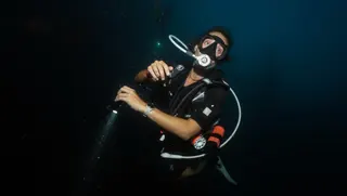 Diver using a torch during the SSI Night Diving and Limited Visibility Specialty course at Echo Divers Koh Tao.