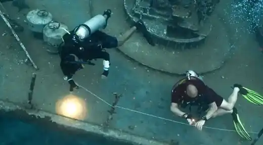 Two scuba divers practising line awareness and positioning during wreck training on the HTMS Suphairin in Koh Tao, Thailand
