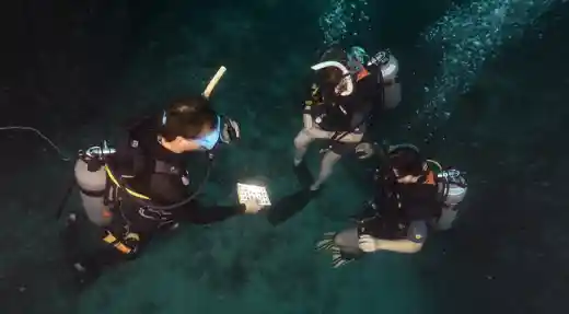 SSI Deep Specialty instructor performing depth-related skill checks underwater with students during a training dive at Echo Divers Koh Tao.