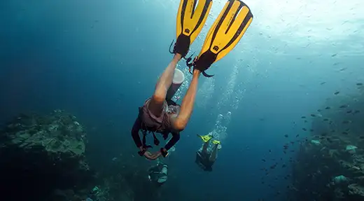 Echo Divers Koh Tao SSI Deep Specialty divers descending into deeper water between reef walls, Koh Tao, Thailand