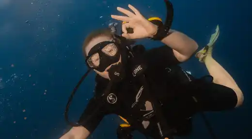 Echo Divers Koh Tao SSI Open Water course student giving the OK signal while hovering underwater, Koh Tao, Thailand