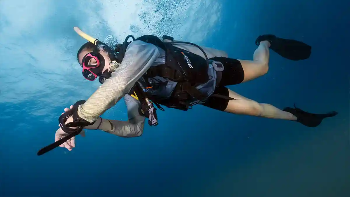 Scuba diver practising skills underwater with bubbles rising in blue water, Koh Tao, Thailand